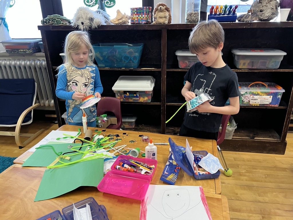 Two students working with pipe cleaners and colored paper