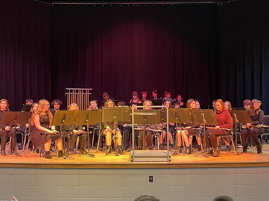 The middle school band sits on the stage ready to play