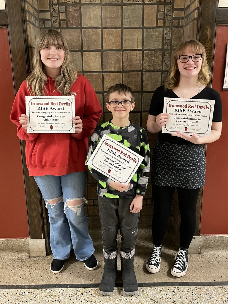 Three students holding certificates for Students of the Month