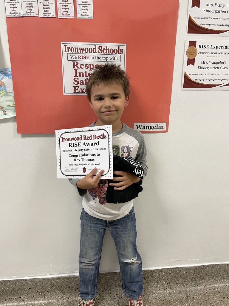 One student holds a Student of the Month certificate