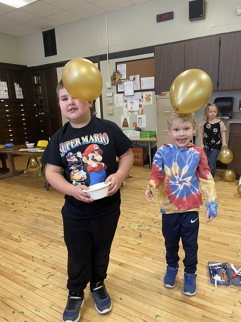 Two students with gold balloons