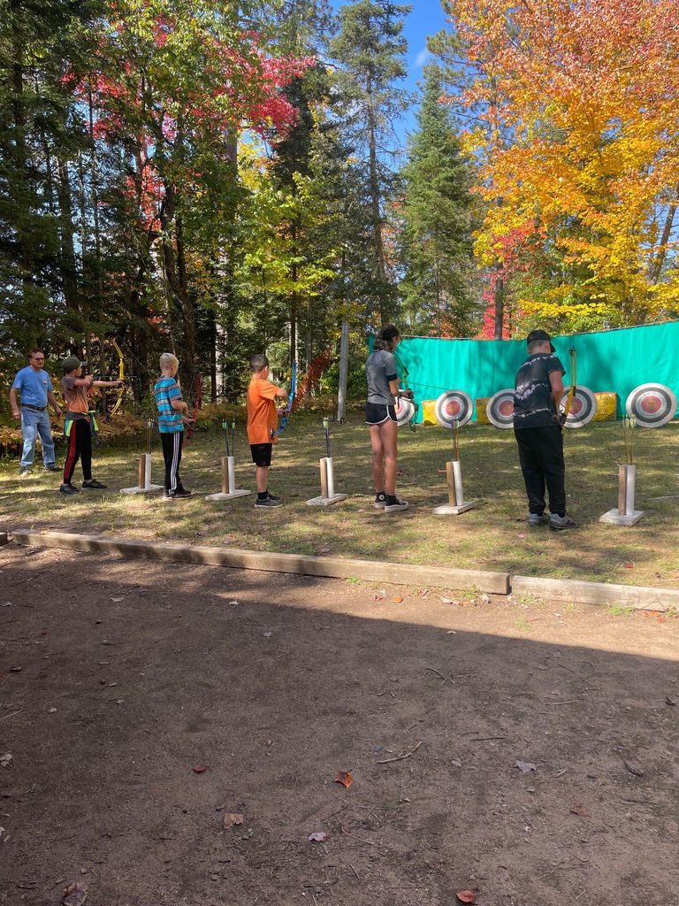 5 students hold bows for archery
